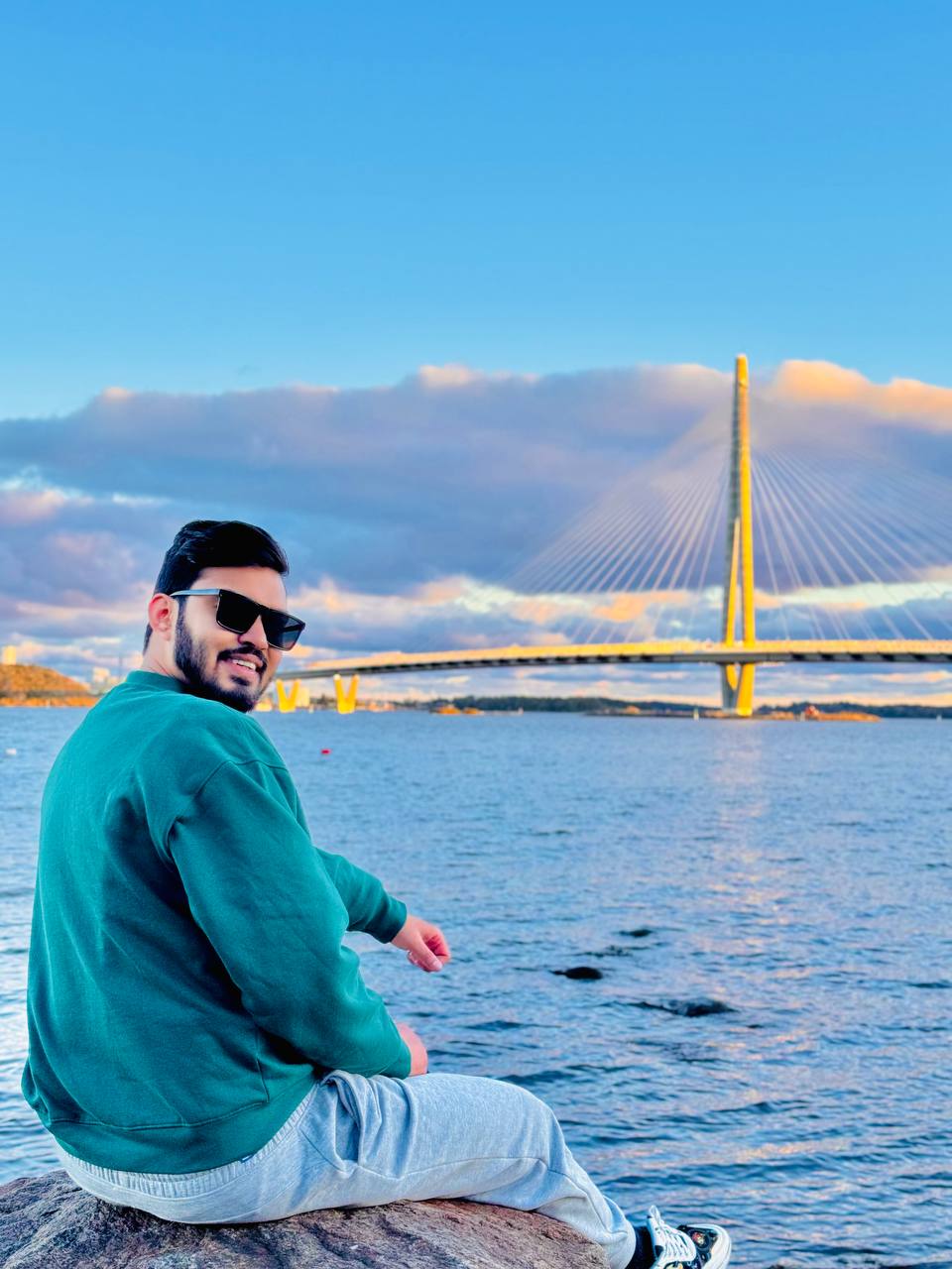 Md Arafat Hossain beside the water with a bridge in the background